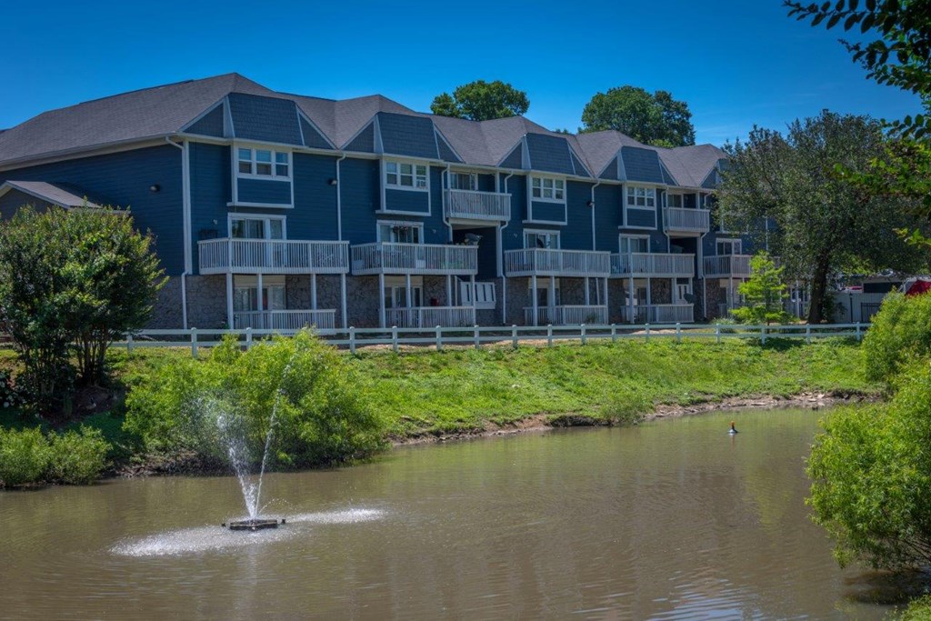 a fountain in the water in front of a building