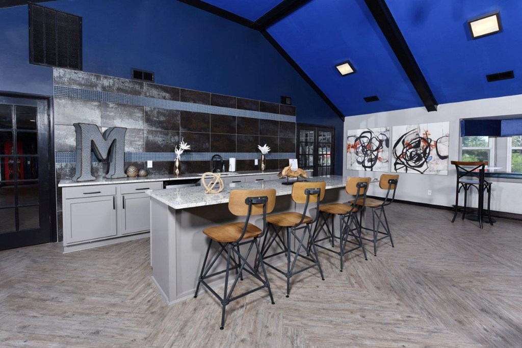 a kitchen with blue ceilings and a bar with stools