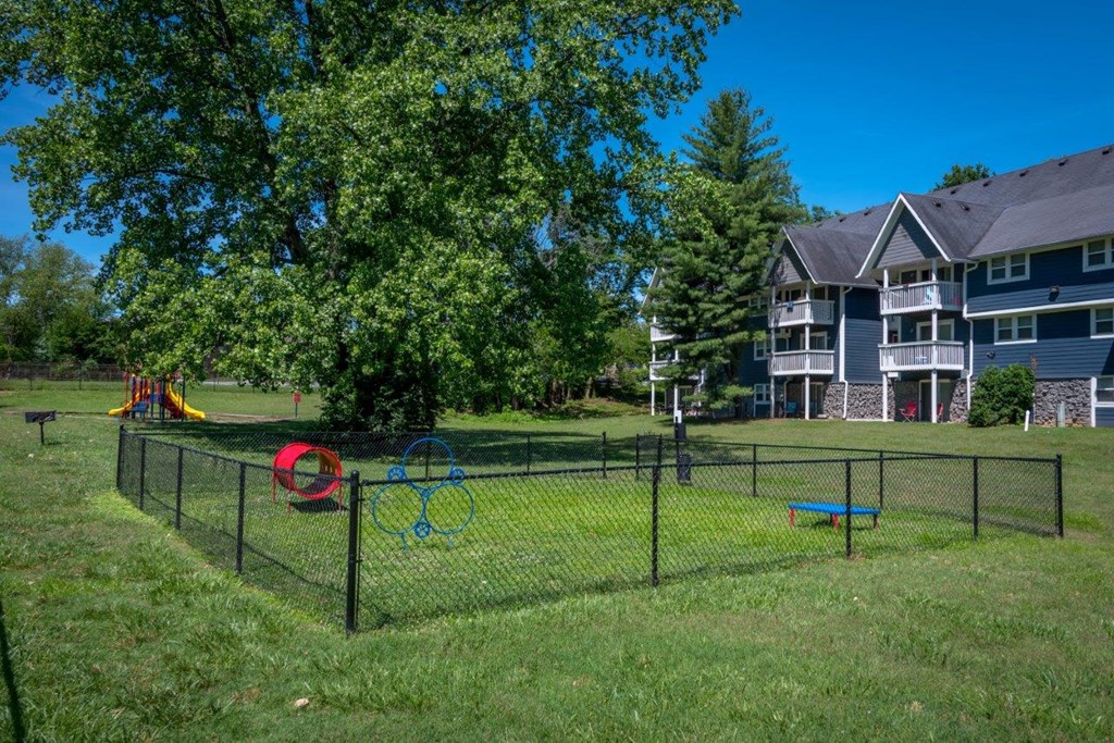 a fenced in play area in the yard of an apartment building
