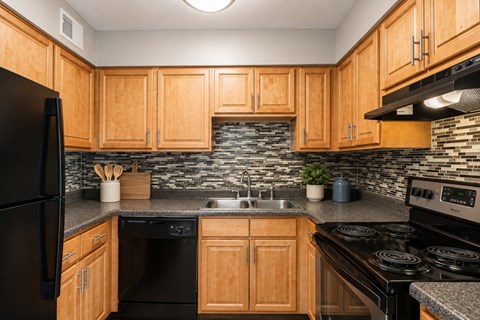 A kitchen with wooden cabinets and black appliances.