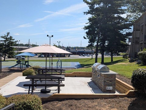 A park with a playground, picnic table, and a gazebo.