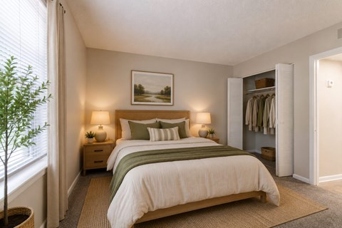 A bedroom with a large bed and a painting on the wall.