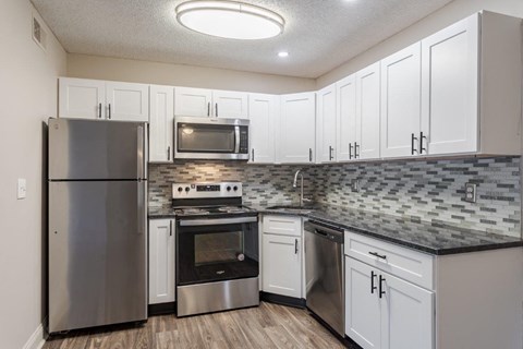 A kitchen with a stainless steel refrigerator, microwave, oven, and dishwasher.