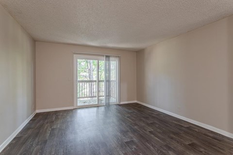 A room with a sliding glass door leading to a balcony.