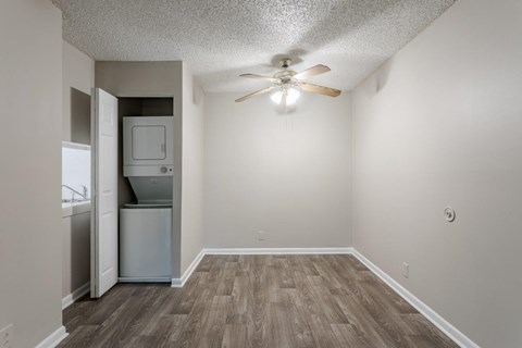 A room with a ceiling fan and a refrigerator.