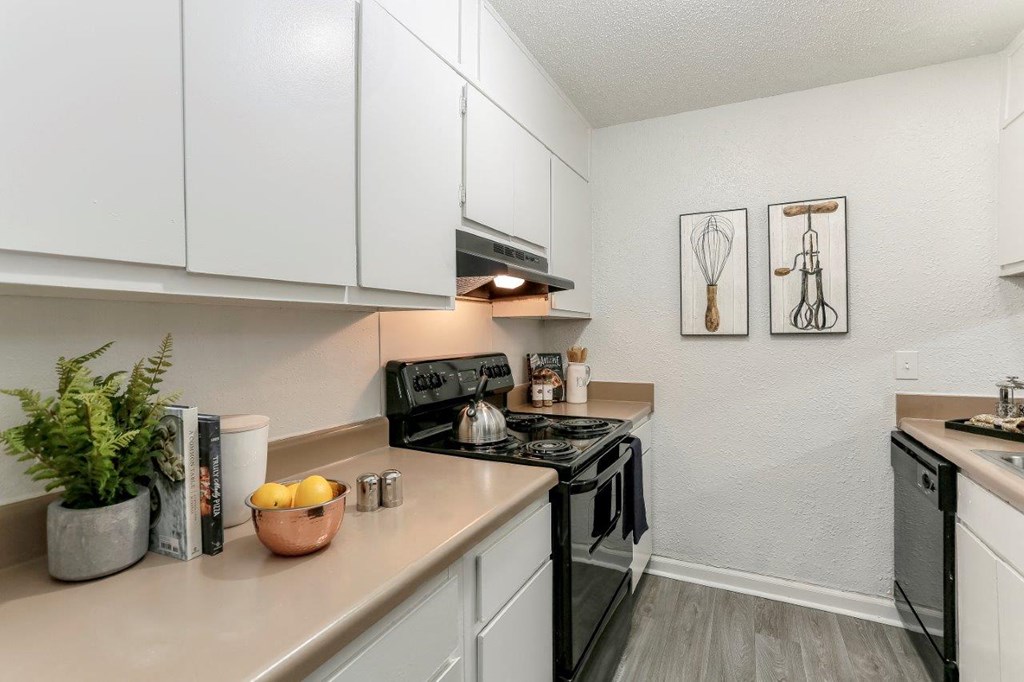 a kitchen with white cabinets and a black stove