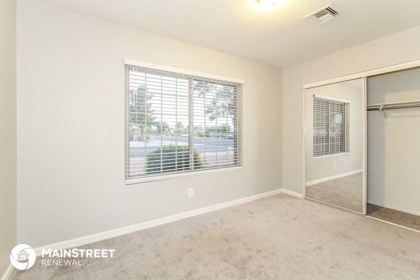 an empty room with a large window and a closet