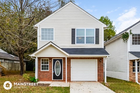 the front of a white house with a white garage door
