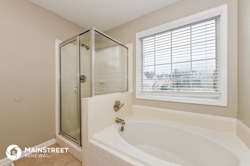 a bathroom with a tub and a shower and a window