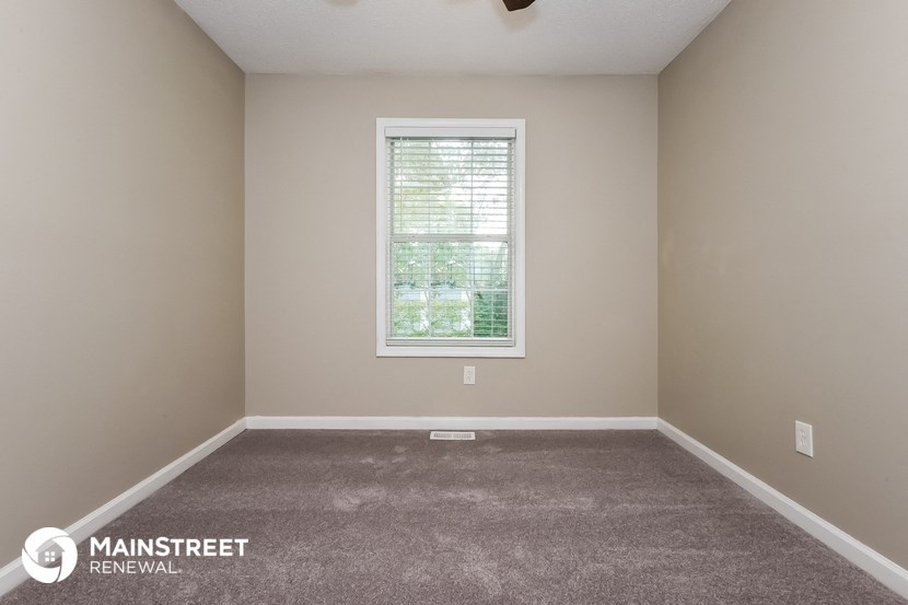 a carpeted room with a window in it