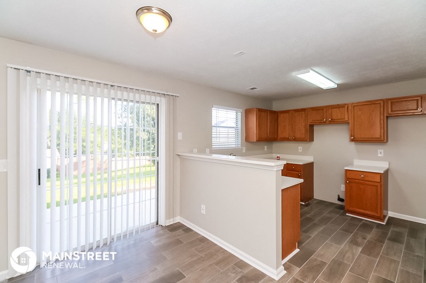 a kitchen with a sliding glass door to the patio