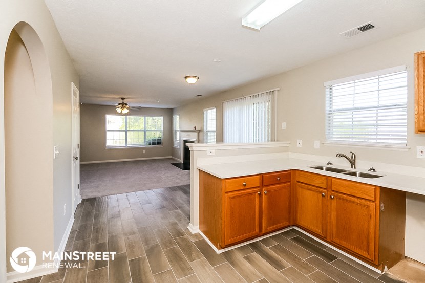 an open kitchen and living room with a sink and counter top