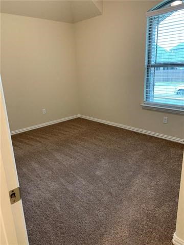 an empty room with a window and a carpet