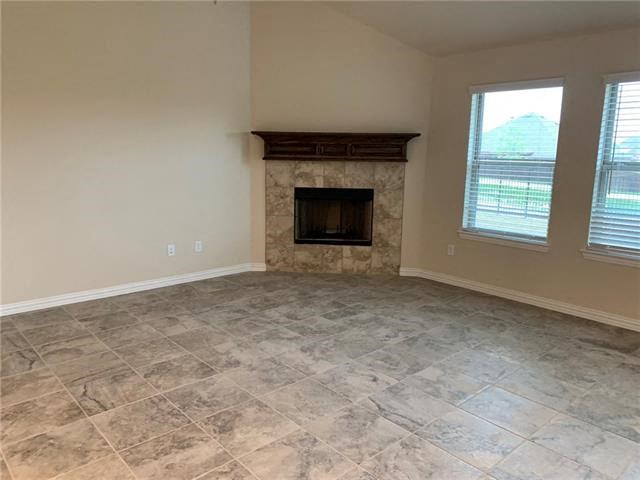 a empty living room with a fireplace and tiled floors