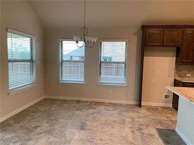 an empty room with a kitchen and a window