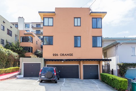 A two-story house with a garage and a car parked in front.