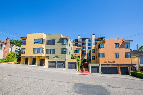 A row of modern townhouses with garages and driveways.