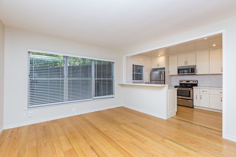 A kitchen with white cabinets and wooden floors.