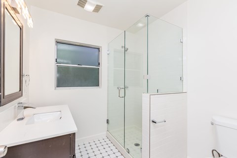 A white bathroom with a glass shower door.