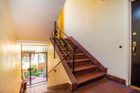 A staircase with a metal railing leads to a balcony.