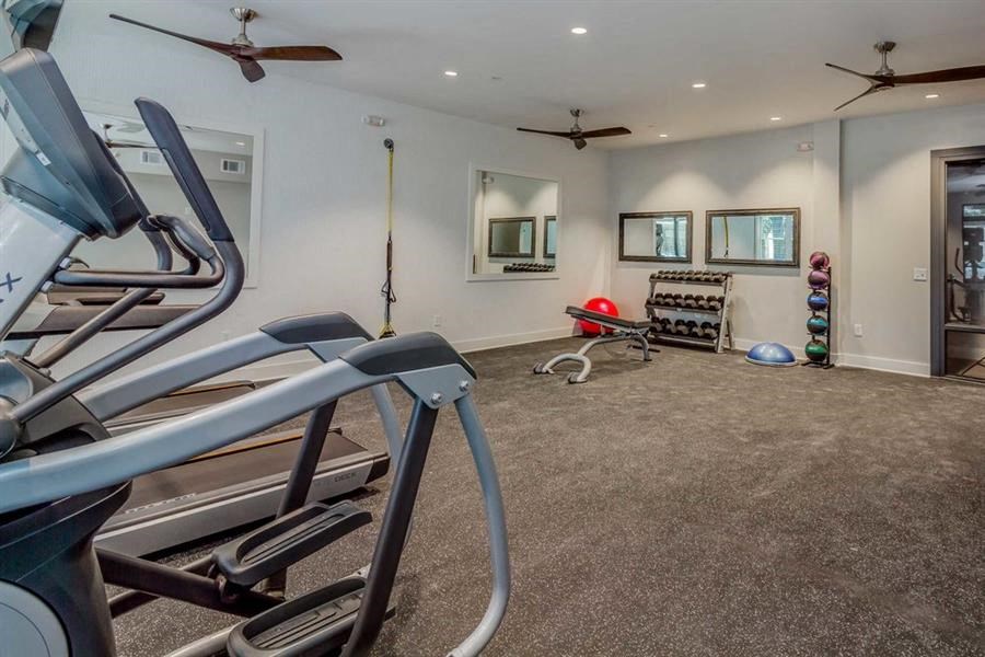 the gym has plenty of exercise equipment and a mirror