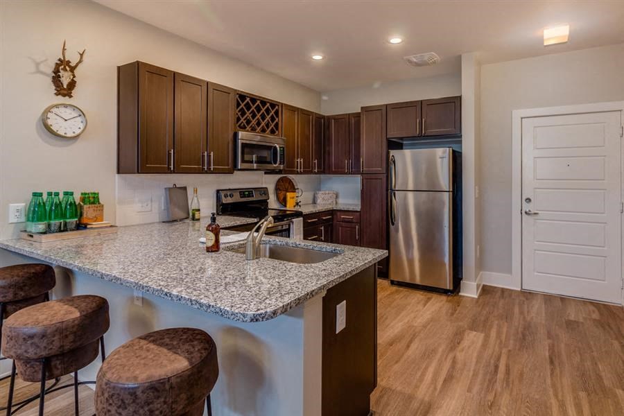 a kitchen with a granite counter top and a stainless steel refrigerator
