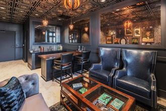 the lobby of a bar with leather chairs and a table