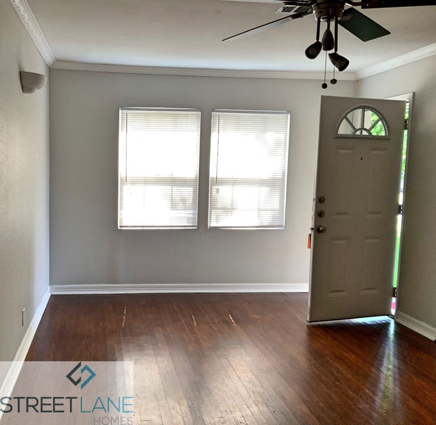 an empty room with a door and two windows