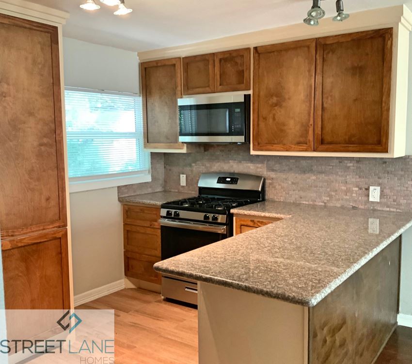a kitchen with a granite counter top and a stove and microwave