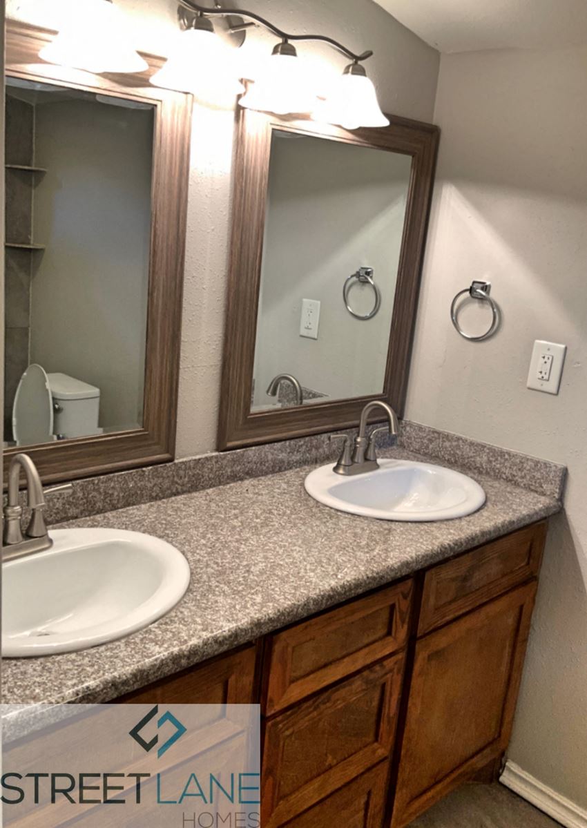 a bathroom with two sinks and two mirrors