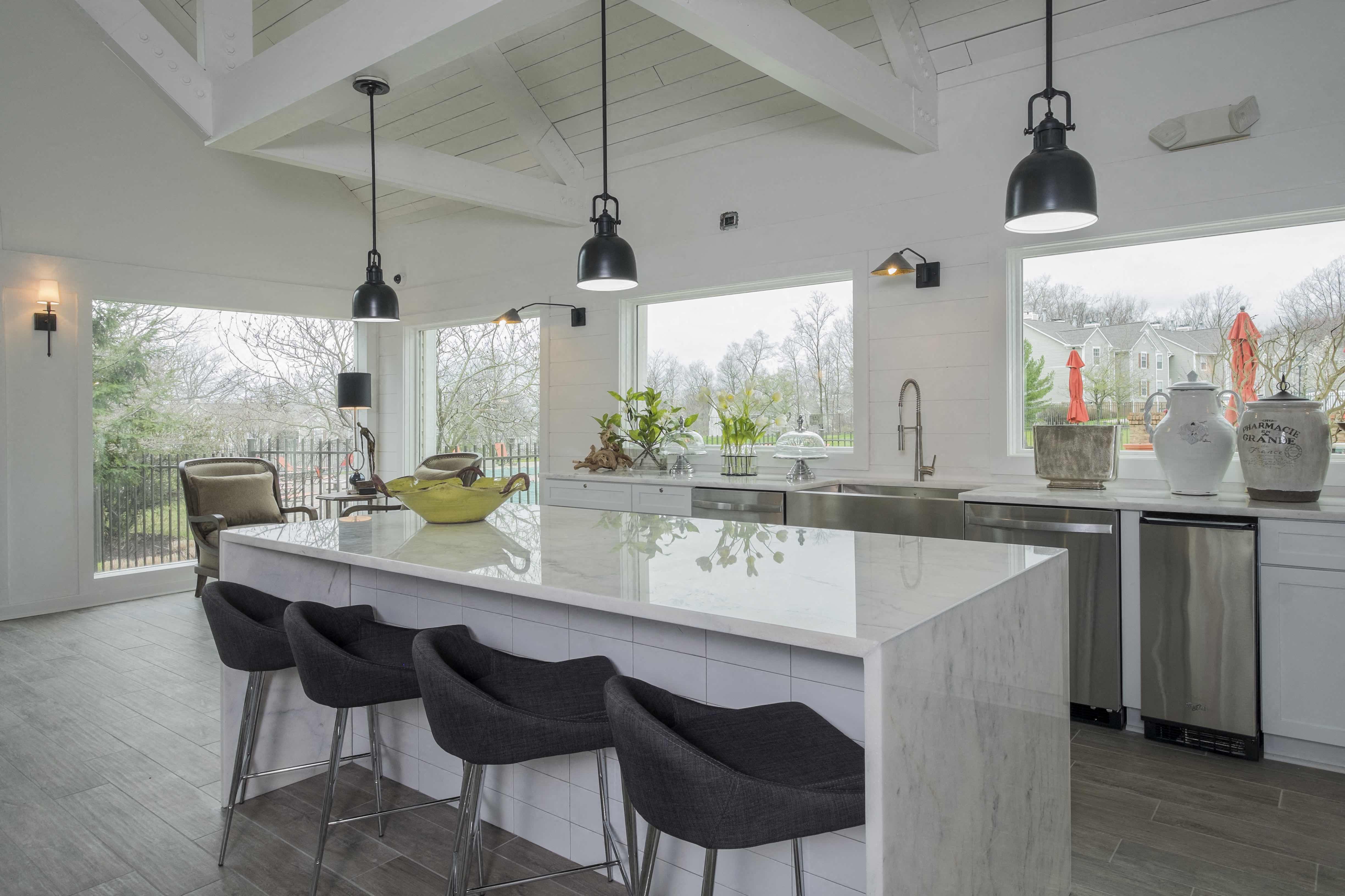 a kitchen with a large marble counter top and chairs