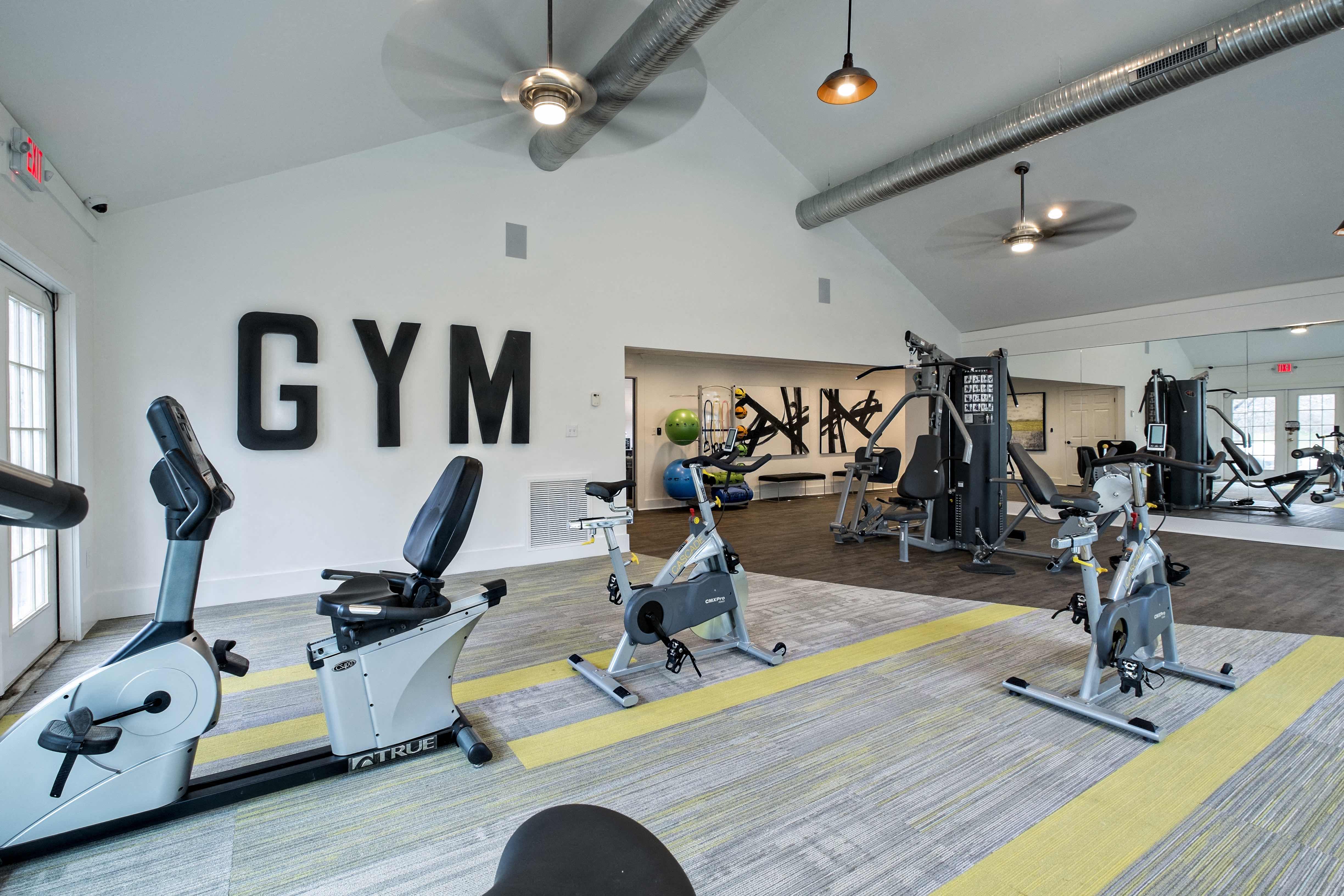 a gym with cardio machines and weights at the district at highland village apartments