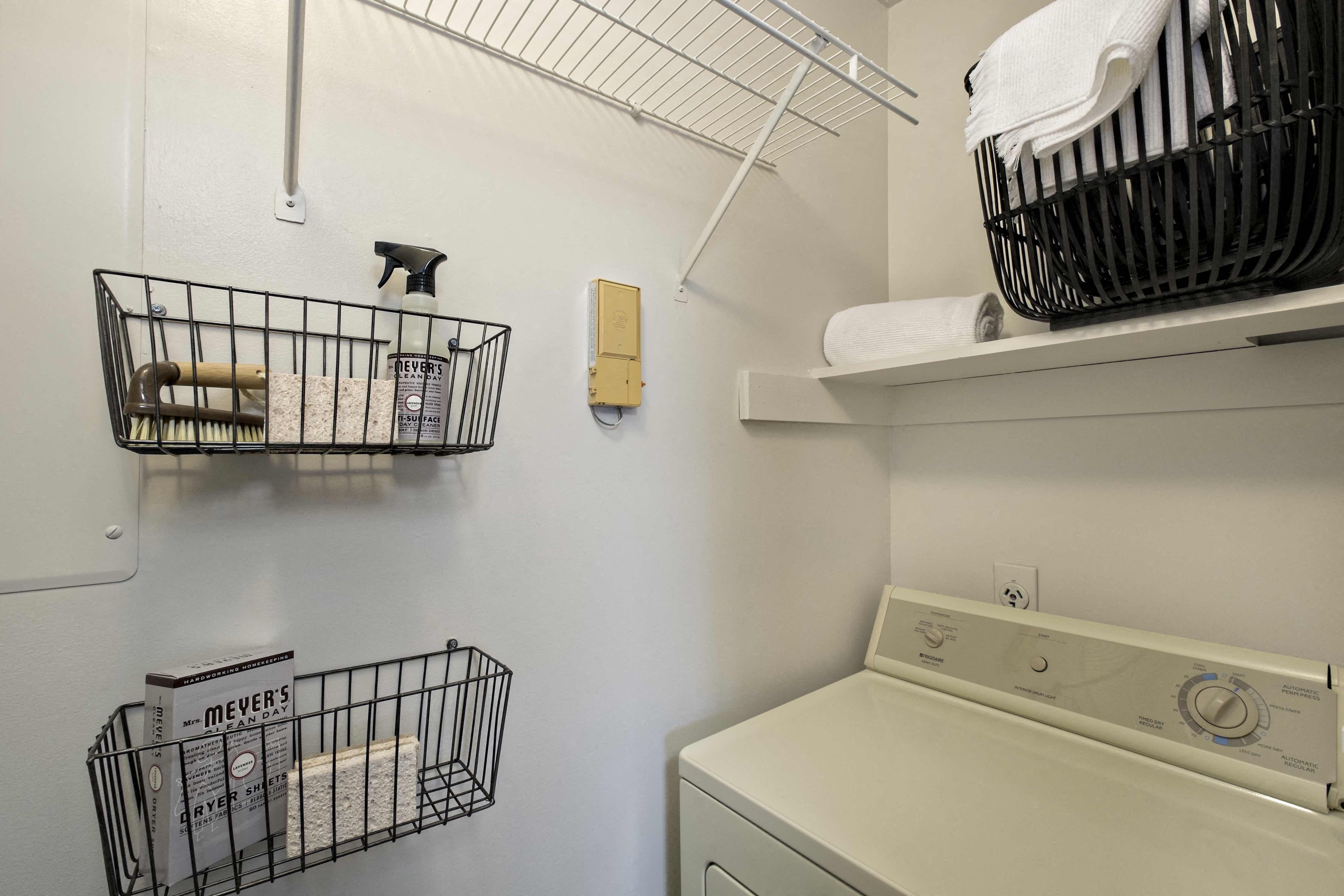 a washer and dryer in a laundry room with baskets on the wall