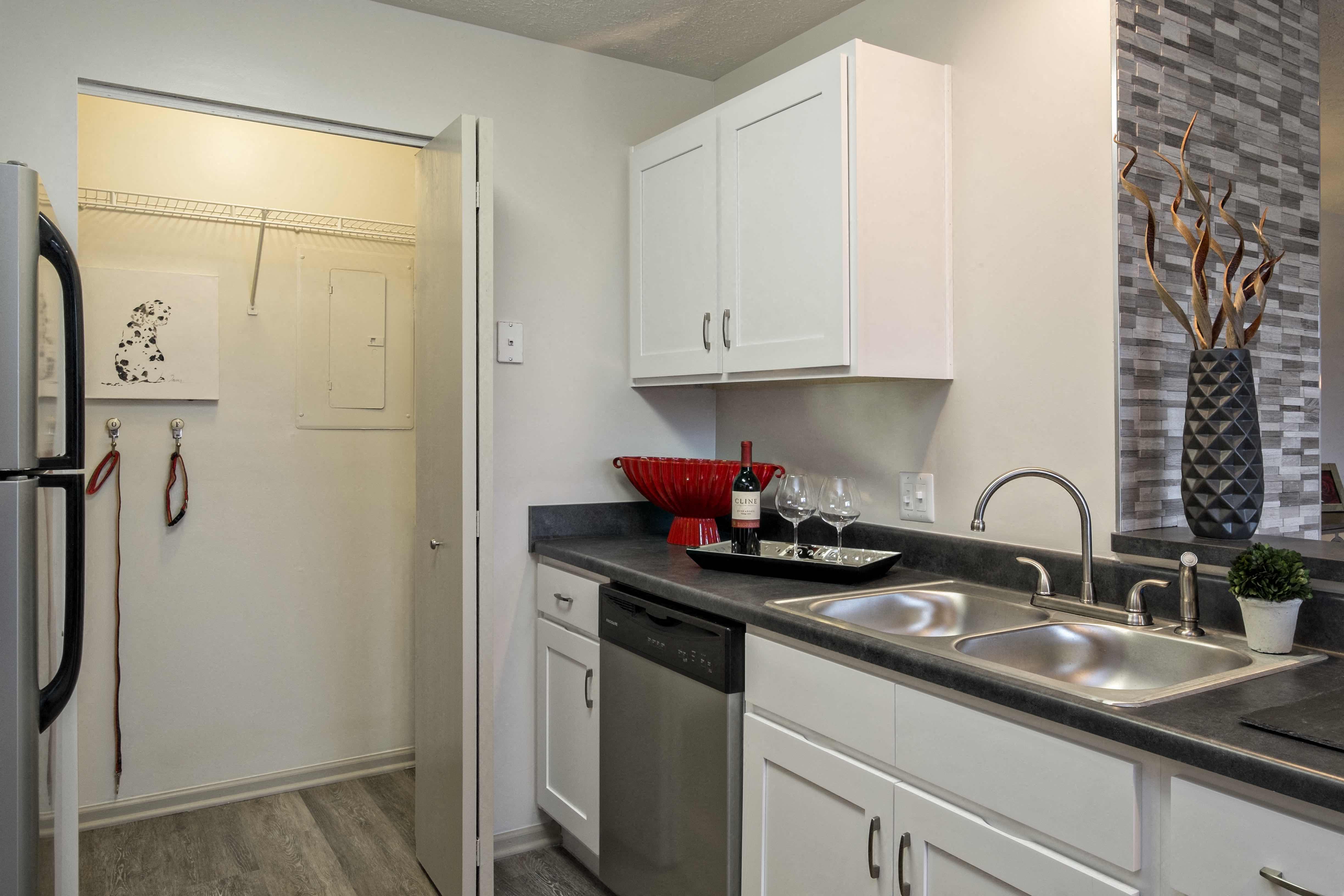 a kitchen with white cabinets and a sink and a refrigerator