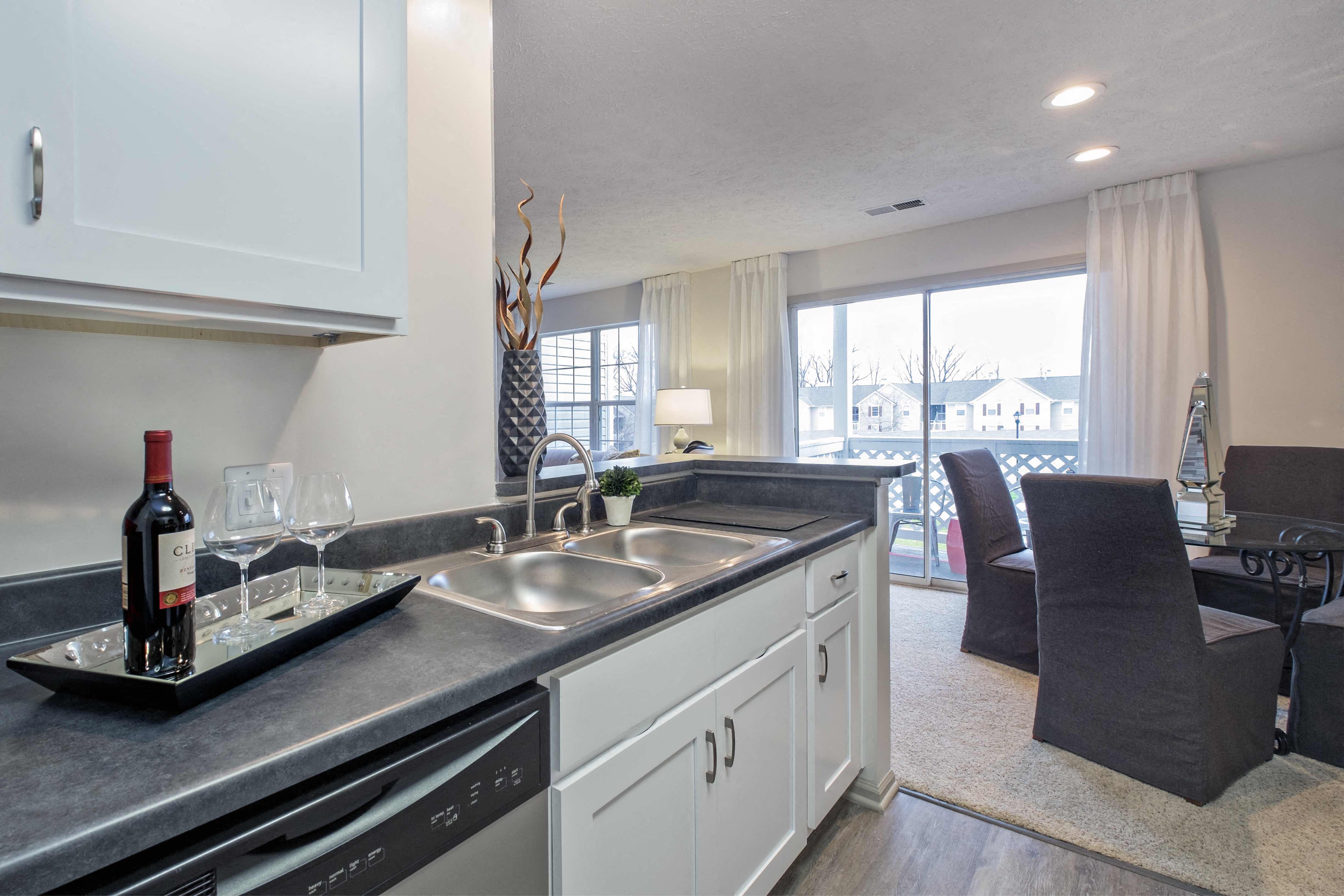a kitchen and living room with a sink and a window