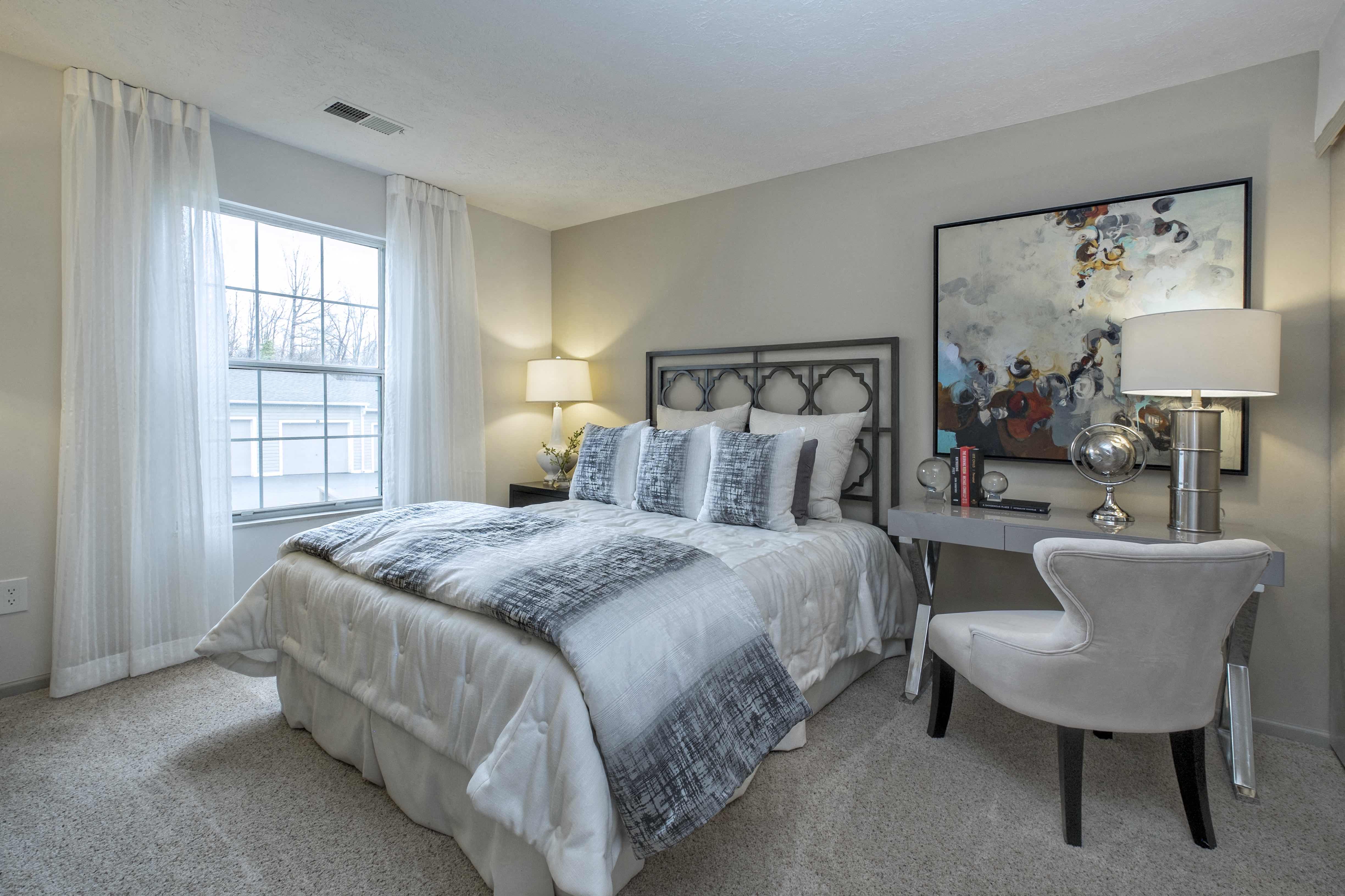 a bedroom with a bed and a desk with a chair