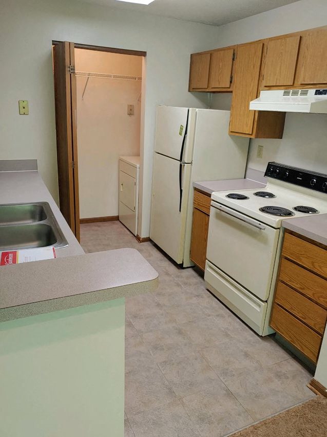 a kitchen with a stove refrigerator and a sink