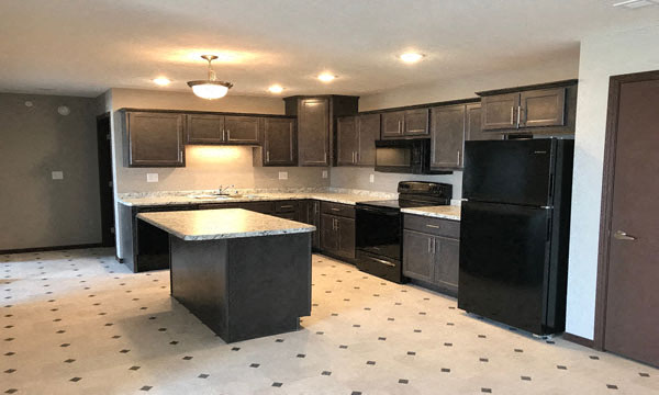 Large kitchen with dark brown cabinets, center island and granite counter tops