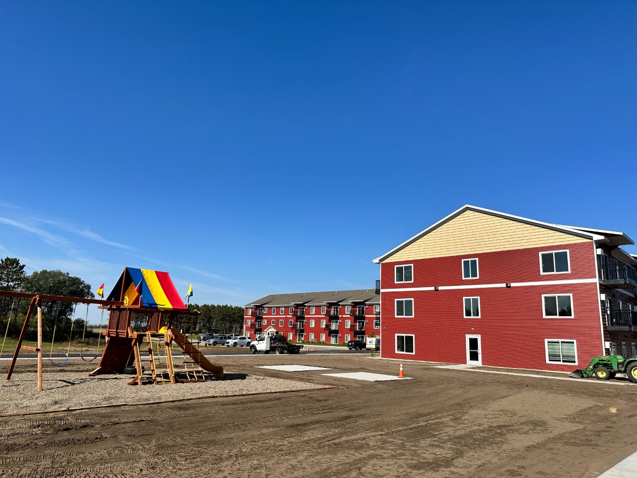 a playground in front of a red building
