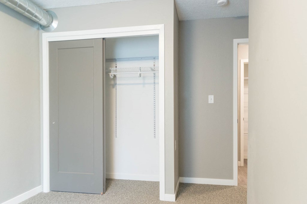 a closet with a white door and a closet door open