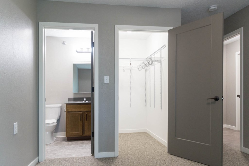 a bathroom with a closet and a toilet and a shower and a bathroom door open