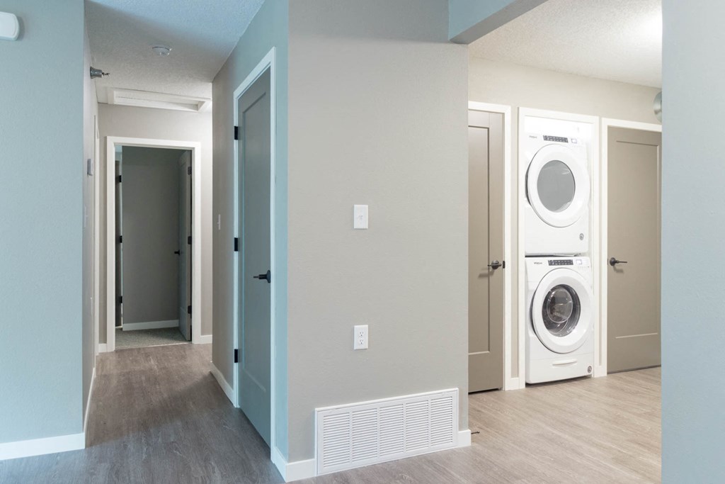 a laundry room with a washer and dryer and a door to a closet