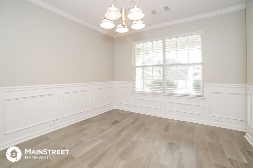 the living room after remodeling with wood flooring and white walls