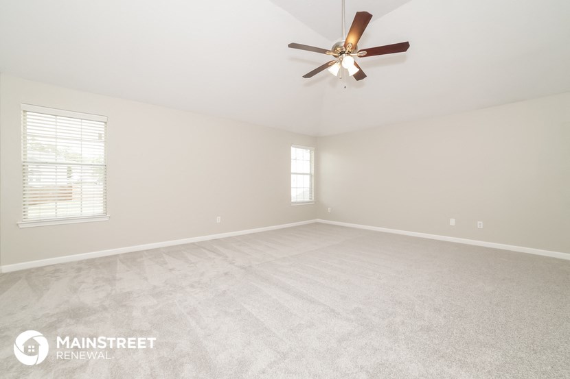 the master bedroom is spacious and clean with a ceiling fan