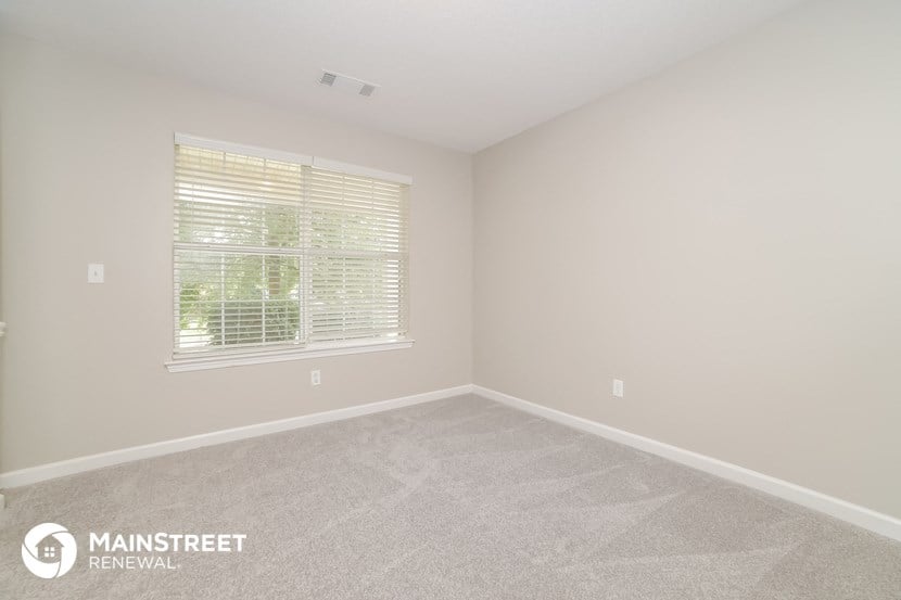 the upstairs bedroom with carpet and window