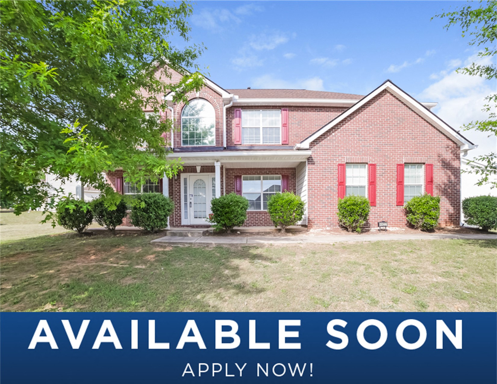a red brick house with a lawn and trees