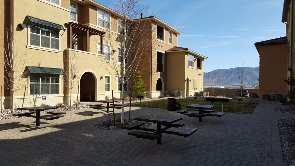 a group of picnic benches in front of a building
