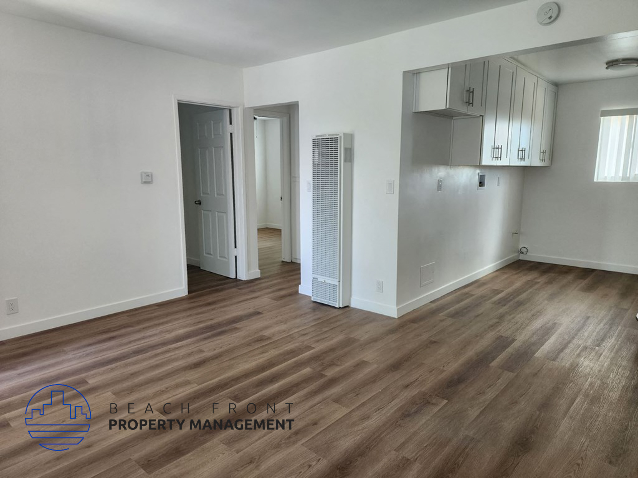 an empty living room with white walls and wood flooring