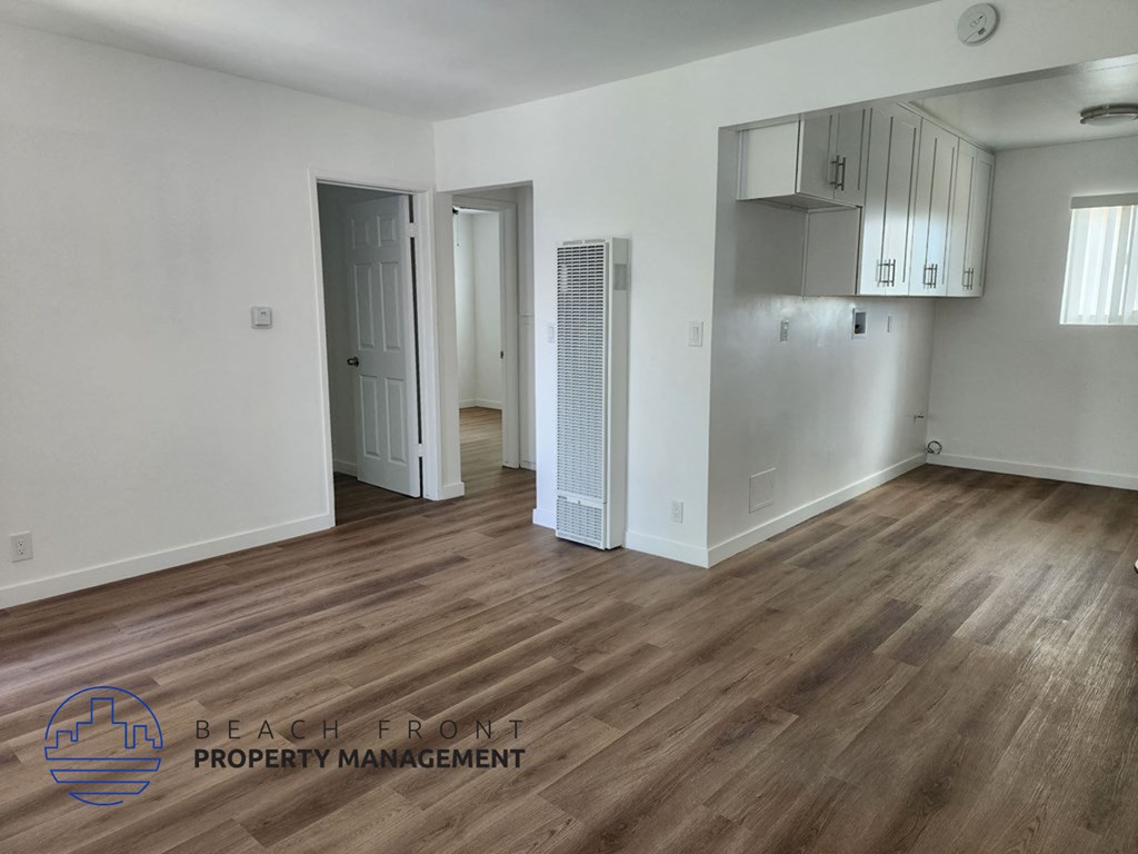 an empty living room with white walls and wood flooring