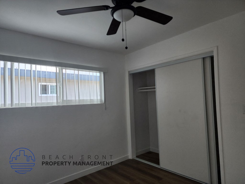 a bedroom with a ceiling fan and a closet